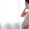 Pregnant Woman Wearing Pollution Mask At Home