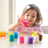 Toddler girl playing with playdough on kitchen counter