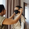 mother-putting-a-face-mask-on-her-daughter-4261252-scaled-1